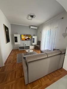 a living room with a couch and a tv at Apartments Green Oasis in Vlašići