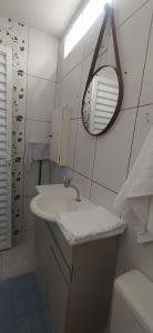 a white bathroom with a sink and a mirror at Studio 1 in Jundiaí