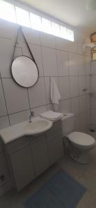 a white bathroom with a toilet and a sink at Studio 1 in Jundiaí