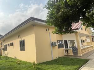 a yellow house with a red roof at The Vicarage in Lashibi