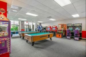 a gaming room with pool tables and arcade machines at Silver Lake Resort in Orlando