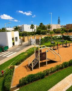 a playground with a slide in a park at Le Ramo - Résidence Ramoflores in Sidi Rahal