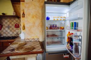an open refrigerator with its door open and food inside at Raggio di sole in Catania