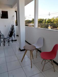 a table and two chairs in a room with a window at Pousada dos Marujos in Pipa