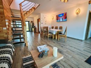 a living room and dining room with a table and chairs at Cabana Magia Muntelui in Prisaca Dornei
