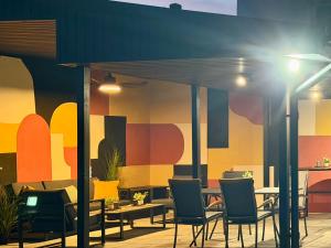 a restaurant with tables and chairs and a colorful wall at Eclectic 6 in Satu Mare