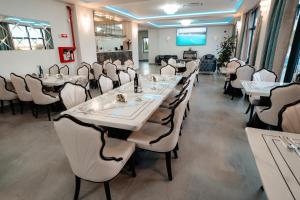 a restaurant with white tables and white chairs at Airport Hotel - Baia Mare - Maramures in Baia Mare