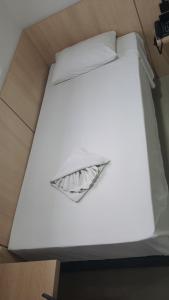 a white bed with a pillow on top of it at GoldMen Express Cianorte in Cianorte