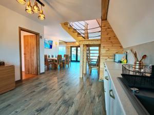a kitchen and living room with a wooden ceiling at Cabana Magia Muntelui in Prisaca Dornei