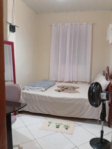 a bedroom with a bed and a window with a fan at Casa do Mandacaru in Bom Jesus da Lapa