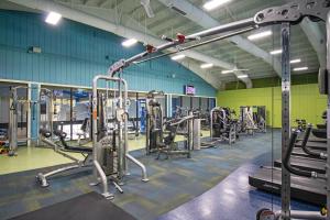a gym with rows of treadmills and machines at The Summit at Massanutten Resort by TripForth in McGaheysville