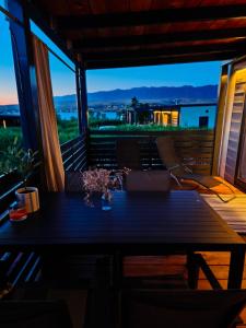 a table on a balcony with a view of the city at Terra Park SpiritoS - Luxury mobile house Ina in Kolan