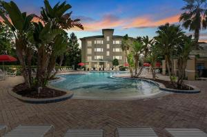 a swimming pool with palm trees in front of a building at Silver Lake Resort in Orlando