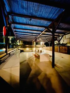 a building with a blue roof with a table and a bench at Kipos Suites & Apartments in Gennadi