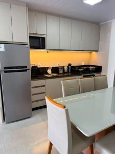 a kitchen with a table with chairs and a refrigerator at Casa de lagoa in Laguna