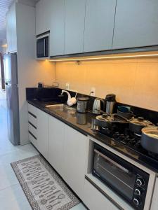 a kitchen with a stove with pots and pans at Casa de lagoa in Laguna +26 photos