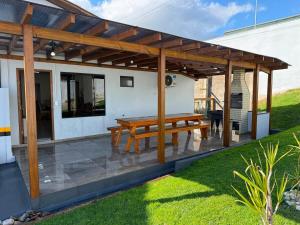 a wooden pergola with a picnic table on a patio at Casa de lagoa in Laguna
