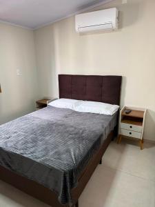 a bedroom with a large bed and a night stand at Casa de lagoa in Laguna
