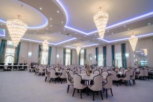 a banquet hall with tables and chairs and chandeliers at Airport Hotel - Baia Mare - Maramures in Baia Mare