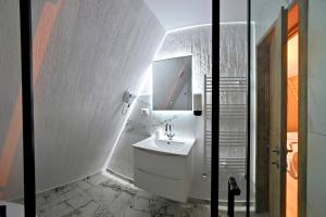 a white bathroom with a sink and a mirror at Cabana Magia Muntelui in Prisaca Dornei +34 photos