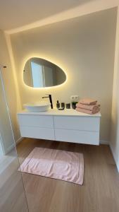 a bathroom with a white sink and a mirror at Kerbault Suites - Martelange in Martelange +5 photos