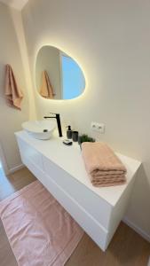 a white bathroom with a sink and a mirror at Kerbault Suites - Martelange in Martelange