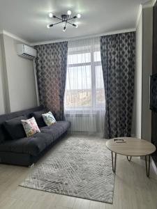 a living room with a couch and a table at Dostar Apartments in Karagandy