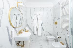 a bathroom with white marble walls and a sink and a mirror at Monastero San Pietro Claver in Rome +54 photos