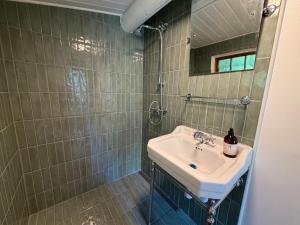 a bathroom with a sink and a mirror at Cozy and authentic log house in Dronningmølle