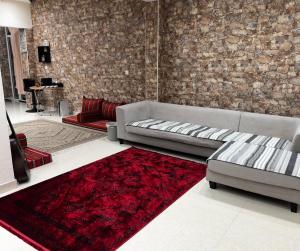 a living room with a couch and a red rug at Dar Shaden hostel in Muscat +64 photos