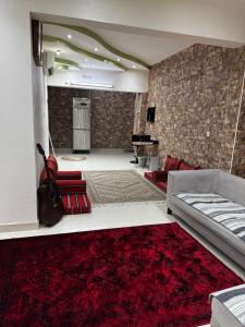 a living room with a couch and a red rug at Dar Shaden hostel in Muscat