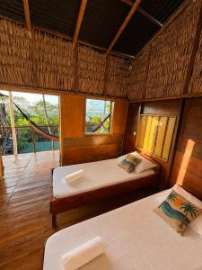 a bedroom with two beds in a room with windows at DuMangue Kite House in Guriú