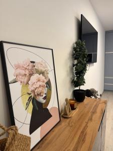 a picture of a woman with pink flowers on a table at Azzurro Room in Zalaegerszeg