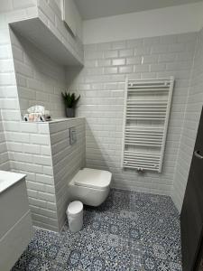 a bathroom with a toilet and a tile floor at Azzurro Room in Zalaegerszeg +11 photos