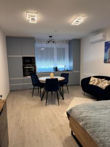 a living room with a bed and a table and chairs at Azzurro Room in Zalaegerszeg