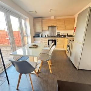 a kitchen with a table and chairs and a refrigerator at NJ&C Properties in Bristol