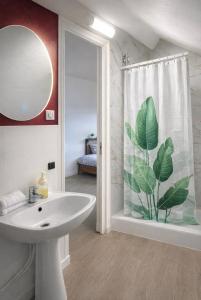 a bathroom with a sink and a large leaf shower curtain at Studio relax in Villeneuve-Saint-Georges