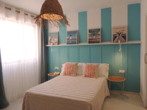 a bedroom with a bed and a blue wall at LOS NAREJOS Hotel in Los Alcázares