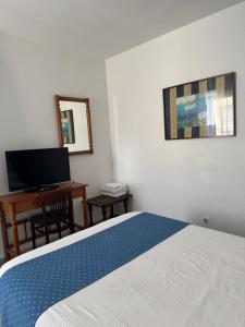 a bedroom with a bed and a desk and a television at Plaça Vella in Sant Carles de la Ràpita