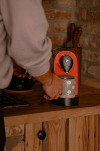 a man is standing next to a coffee maker at Domek na wyłączność w Otulinie Ojcowskiego Parku Narodowego in Wola Kalinowska
