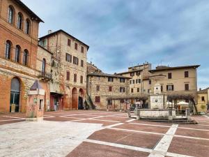 a courtyard in an old building with a fountain at Apartamento vicolo delle Rose in Castelnuovo Berardenga
