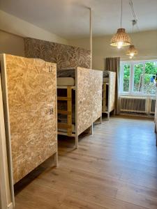 a room with four bunk beds in a room with a floor at Nómada Hostel - Surf & pilgrim House in San Vicente de la Barquera