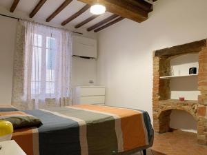 a bedroom with a bed and a brick fireplace at Apartamento vicolo delle Rose in Castelnuovo Berardenga