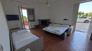 a room with two beds and a television in it at Grecale in Centola
