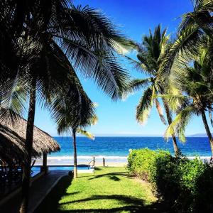 a view of the beach from a resort with palm trees at Tranquilidad Total Frente al Mar I 3 Hab y Alberca in Barra de Potosi +34 photos