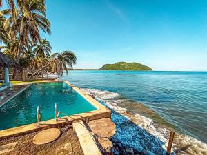 a swimming pool with a view of the ocean at Tranquilidad Total Frente al Mar I 3 Hab y Alberca in Barra de Potosi