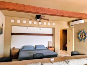 a bedroom with a bed and a ceiling fan at Tranquilidad Total Frente al Mar I 3 Hab y Alberca in Barra de Potosi