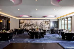 a room with tables and chairs and a large painting at W Minneapolis - The Foshay in Minneapolis