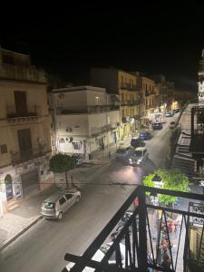 a city street at night with cars parked on the street at Elysium Luxury Suite in Trabia