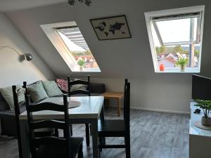 a living room with a table and a couch and two windows at EazyStay in Avonmouth